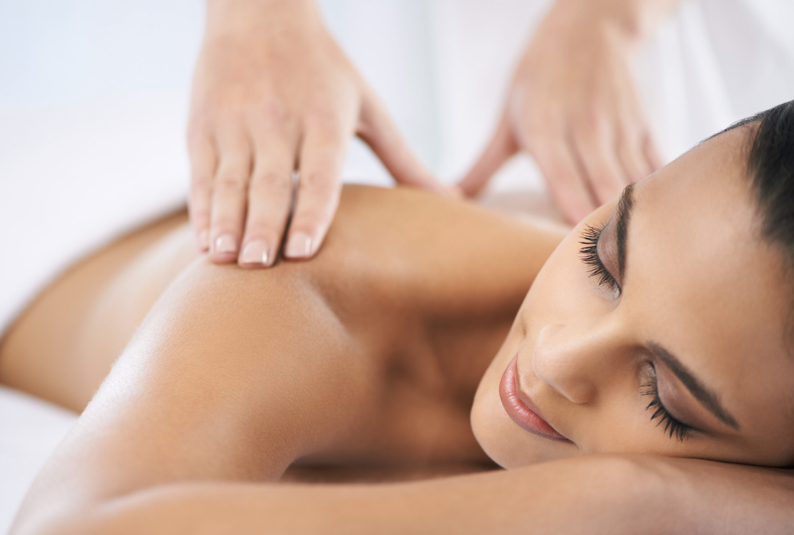A young woman receiving a massage from a massage professional